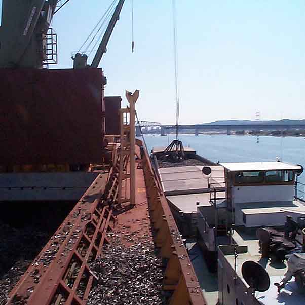 Transport fluvial et transbordement direct sur navire de déchets de métaux au port de Caronte.